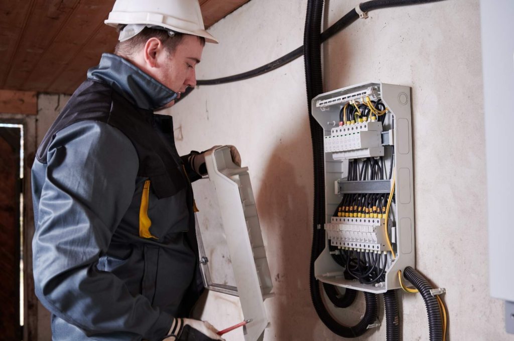 Reliable emergency electrician in New York working on electrical panel